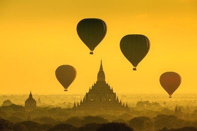 hot air balloon over plain of bagan at sunrise, myanmar