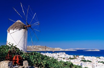traditional windmill overlooking mykonos town in morning light, mykonos island, cyclades, greece