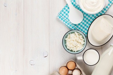 dairy products on wooden table. sour cream, milk, cheese, eggs and yogurt. top view with copy space