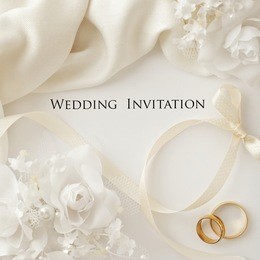two wedding rings and wedding invitation