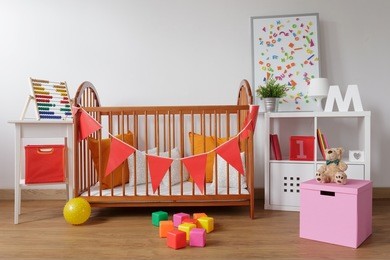 photo of stylish room for babygirl with wooden crib