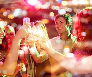 party, holidays, celebration, nightlife and people concept - smiling friends clinking glasses of champagne in club