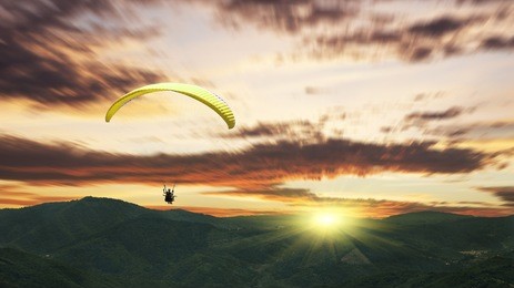 paragliding at sunset with purple clouds