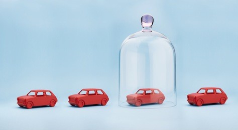 toy car protected under a glass dome on blue background