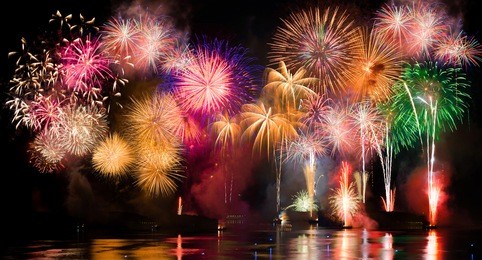 colorful fireworks. fireworks are a class of explosive pyrotechnic devices used for aesthetic and entertainment purposes. visible noise due to low light, soft focus, shallow dof, slight motion blur