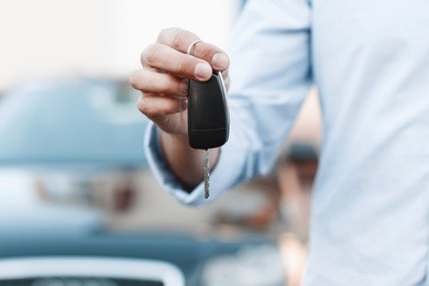 businessman holding a car key.