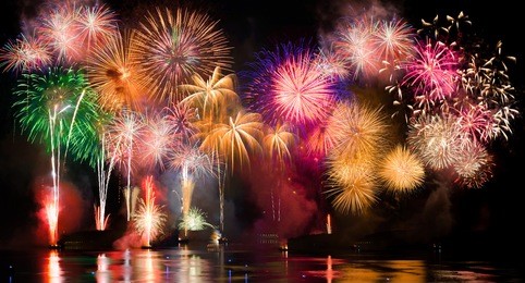 colorful fireworks. fireworks are a class of explosive pyrotechnic devices used for aesthetic and entertainment purposes. visible noise due to low light, soft focus, shallow dof, slight motion blur