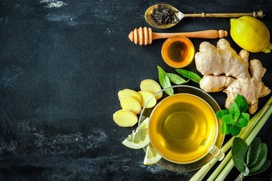 cup of ginger tea with lemon and honey on slate plate