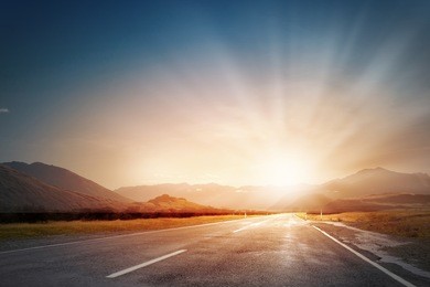 empty asphalt road and sun rising at skyline