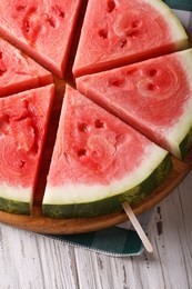 chopped fresh watermelon on a stick close-up on the table. vertical