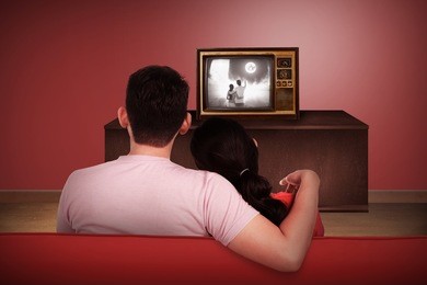 young asian couple watching retro tv in the house