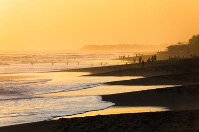 silhouettes of people at sunset on kuta beach in bali, indonesia