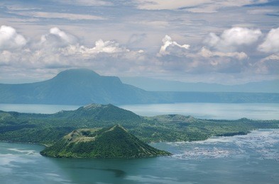 a view of the famous taal volcano and taal lake in tagaytay  city, philippines. fish farms and small boats are strewn all over the right side of the volcano.
