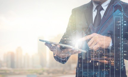 double exposure of businessman using the tablet with cityscape and financial graph on blurred building background, business trading concept