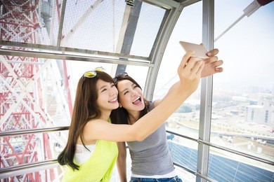 happy women girlfriends taking a selfie in ferris wheel