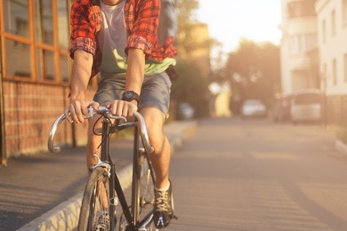 close up hipster on bike in the city at sunset. shot with sunflare and without face.