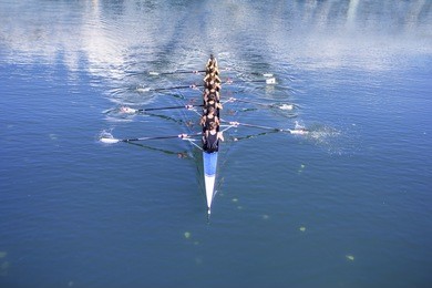 rowers in eight-oar rowing boats on the tranquil lake