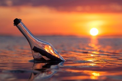 bottle with a message in the sea at sunset
