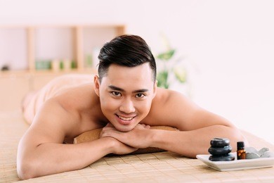portrait of smiling vietnamese young man at the spa salon