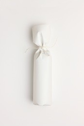 gift bottle wrapped in white paper on white background - minimal and elegant image useful as book cover, wine gourmet, gift certificate or dinner invitation