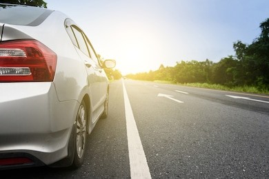 close up side of  silver car and light on the  road