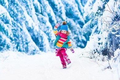 little girl enjoying a sleigh ride. child sledding. toddler kid riding a sledge. children play outdoors in snow. kids sled in the alps mountains in winter. outdoor fun for family christmas vacation.