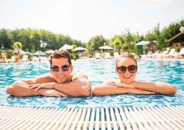 young couple relaxing in resort swimming pool.