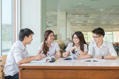 group of asian students in uniform studying together at classroom. 

