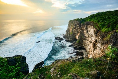 scenic coastal landscape of high cliff at sunset near uluwatu temple, bali island, indonesia