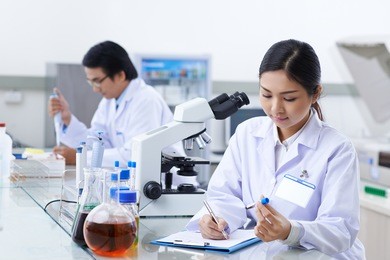 laboratory assistant filling medical report with information about blood test
