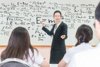 asian teacher with a group of high school students in classroom