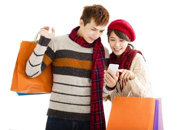 happy couple shopping together and looking smart phone