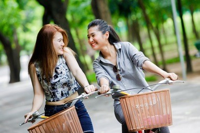 happy young asian woman with bicycle in park