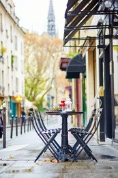 tables of a parisian outdoor cafe decorated for christmas