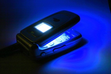 a cell phone glows by the light of its own screen.