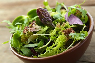 fresh mixed green salad in bowl close up