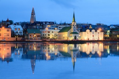 beautiful reflection of the cityscape of reykjavik in lake tjornin at the blue hour in winter