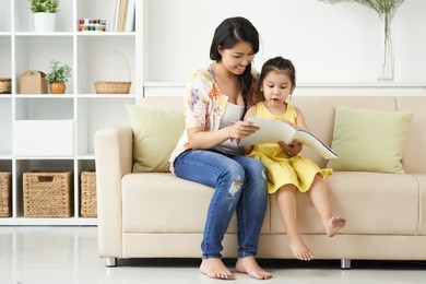 mother and daughter looking at pictures in the magazine
