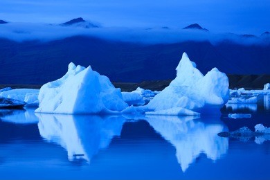 climate change - melting icebergs from vatnajokull glacier floating in jokulsarlon lagoon during the evening.
