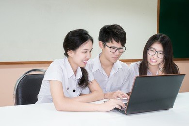 group of asian student in uniform e-learning through laptop in classroom