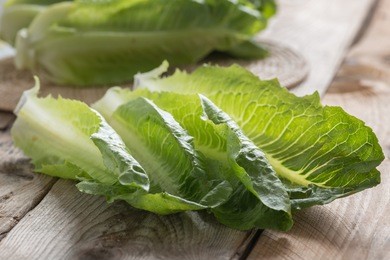 cos lettuce on wood table. selective focus.