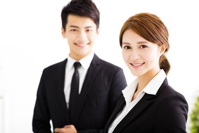 happy business man and woman standing  in office