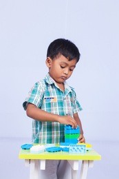 a little asian boy play building brick on white background