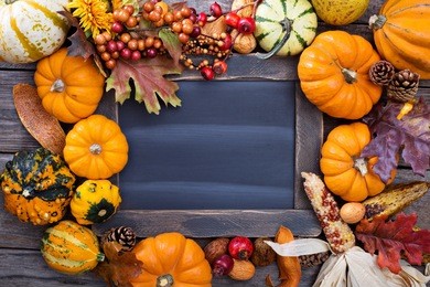 pumpkins and variety of squash around a chalkboard