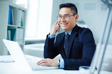 young asian businessman in eyeglasses calling in office