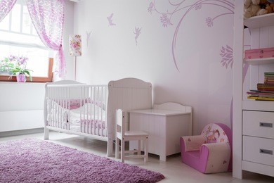 interior of baby room with white furniture and pink details