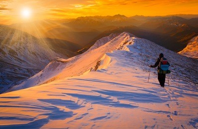beautiful amazing sunset winter mountains.  a man goes a sport hike in snow holidays. christmas background. unique landscape. northern country russia caucasus. quest