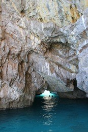 people swimming in a grotto in capri with crystal blue water