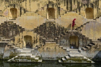 local women crossing the stepwells of chand baori, in jaipur, india. it was built as a monument to the goddess of joy and happiness, hashat mata.