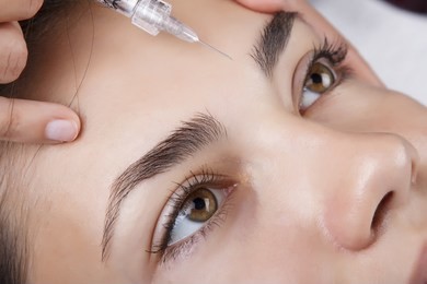 young pretty woman receiving treatments in beauty salons. young beautiful dark-haired woman in the office beautician lying on the couch. contouring procedure , revitalization. beauty injections .